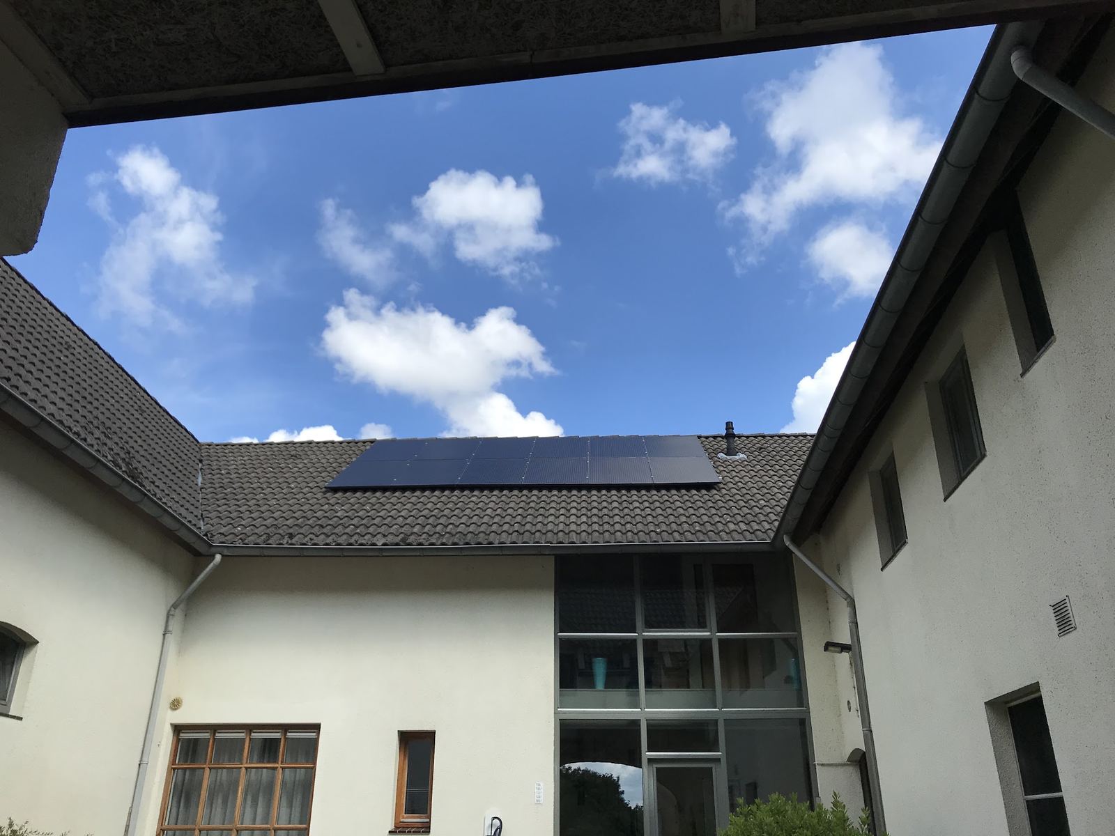 Zonnepanelen op het dak rond de binnenplaats van een witte boerderij