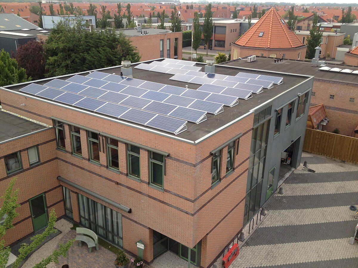 Kantoorpand met een installatie van zonnepanelen op het dak, van bovenaf