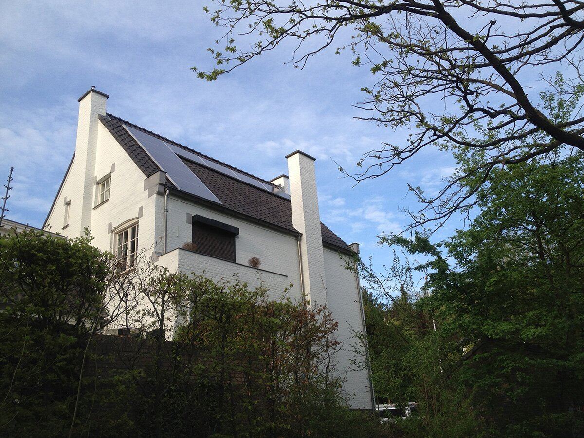 Witte villa met donkere zonnepanelen in het dak