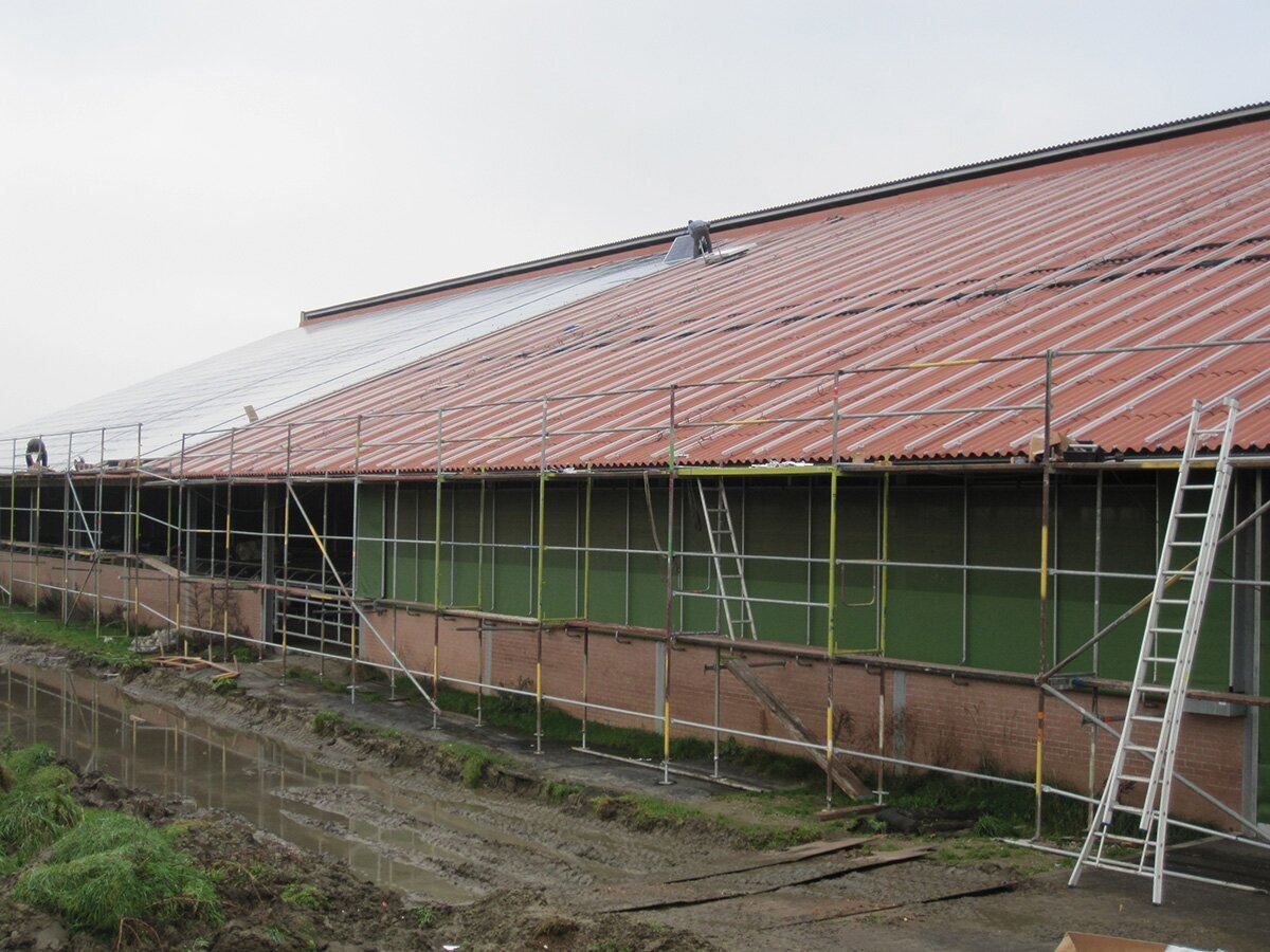 Steiger langs een agrarisch gebouw, klaar voor de plaatsing van panelen